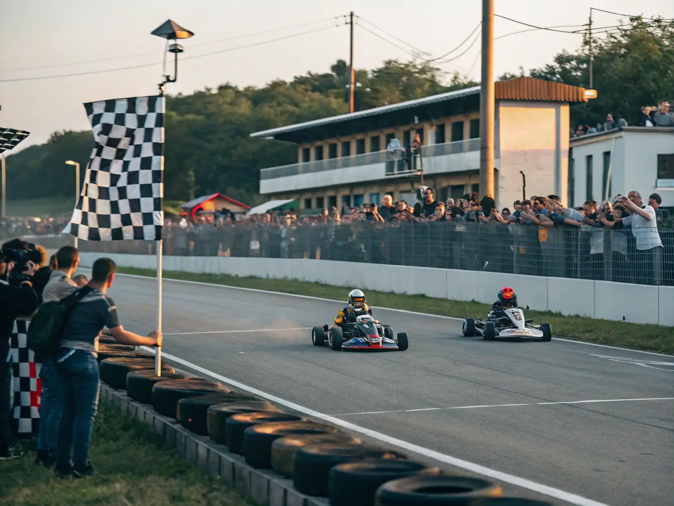 A dynamic image of a competitive karting race, showcasing the speed, skill, and excitement of the event. The setting is a professional karting track with spectators and race officials.