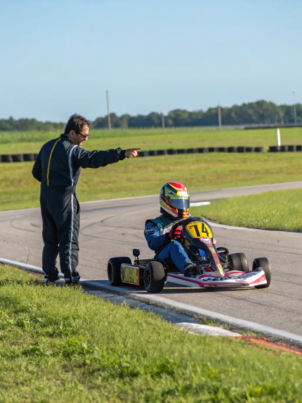 A group of adults participating in a karting race, with karts speeding around a track, showcasing the competitive spirit and camaraderie at ASSOCIATION TEAM RACING AURILLACOIS.
